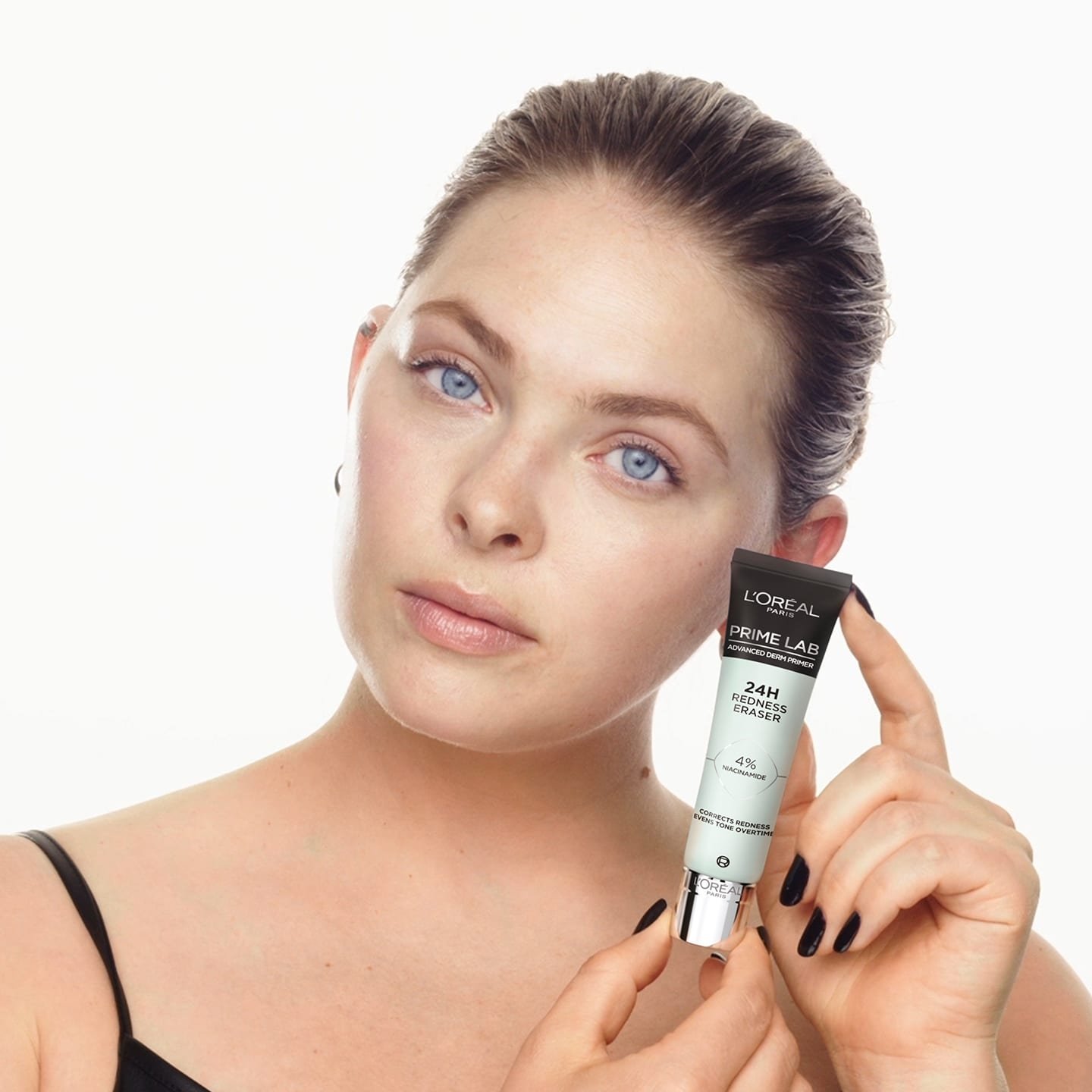 Eine Frau hält Prime Lab 24h Redness Eraser Produkt in ihrer Hand